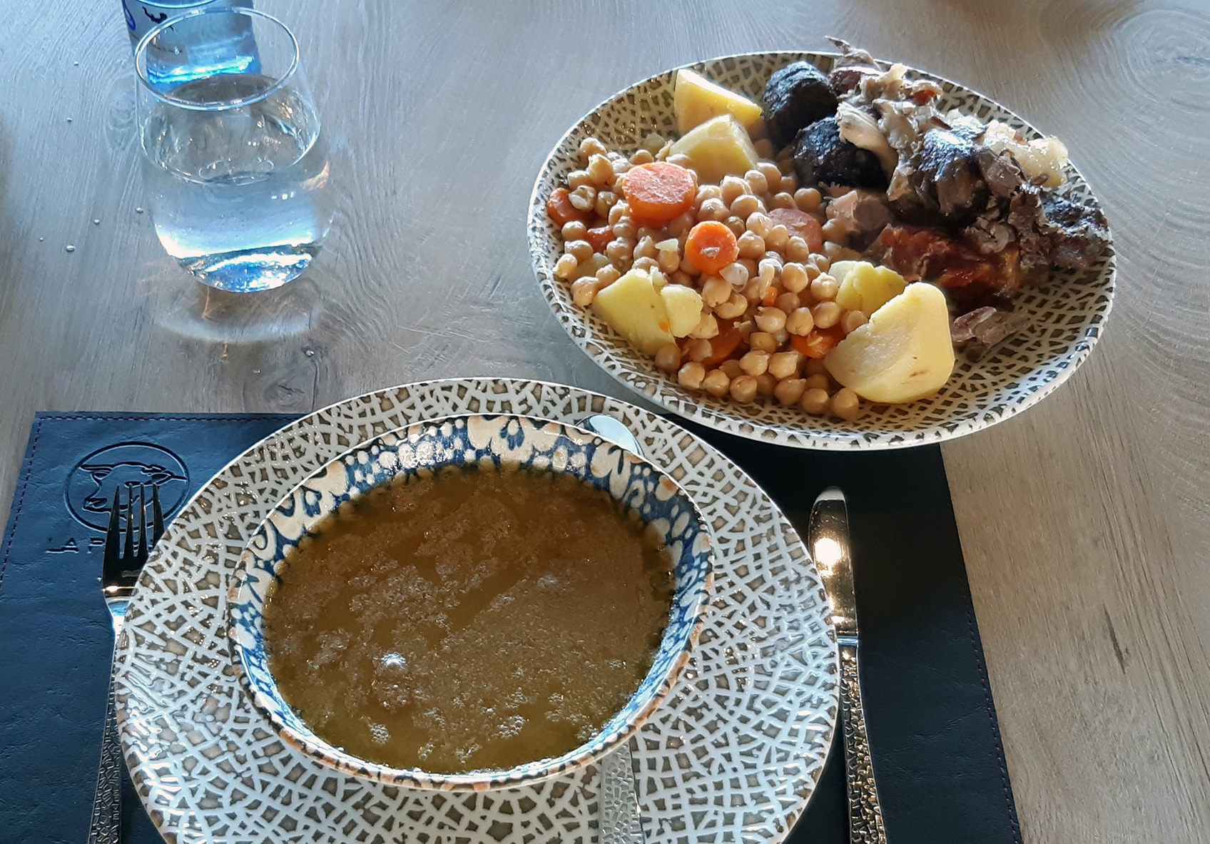 Cocido madrileño tradicional con garbanzos, verduras y carnes en olla de barro